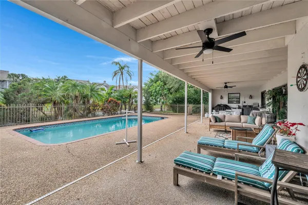 a living room with patio furniture and a floor to ceiling window