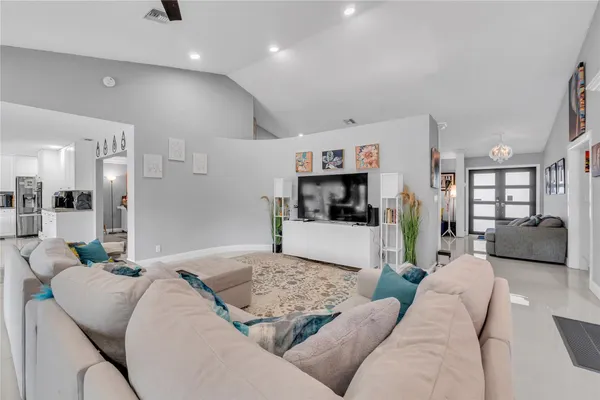 a living room with furniture and a view of kitchen