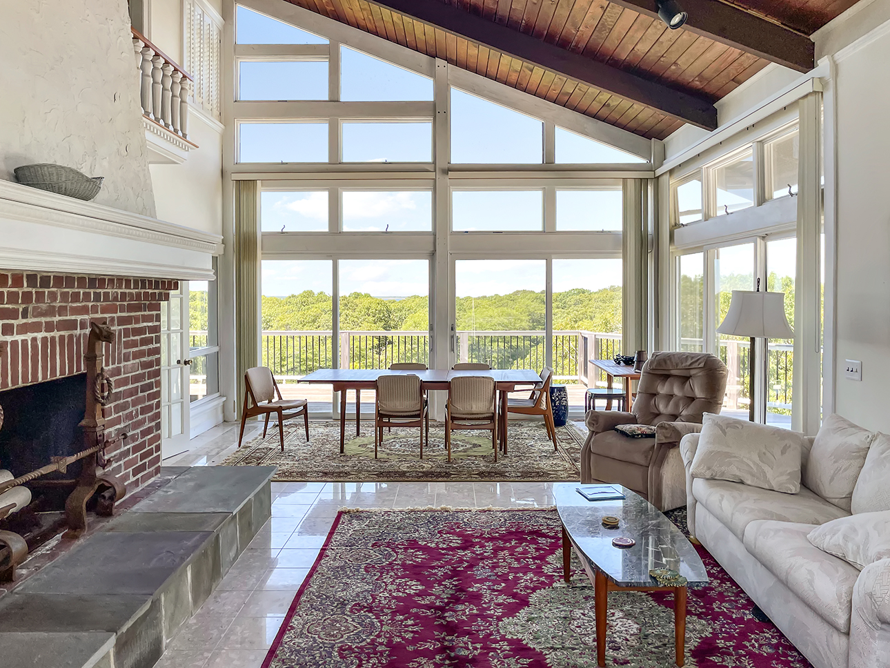 70 Capawock Road West Tisbury, MA 02568 - Photo 10 of 23 a living room with furniture large windows a rug and a fireplace