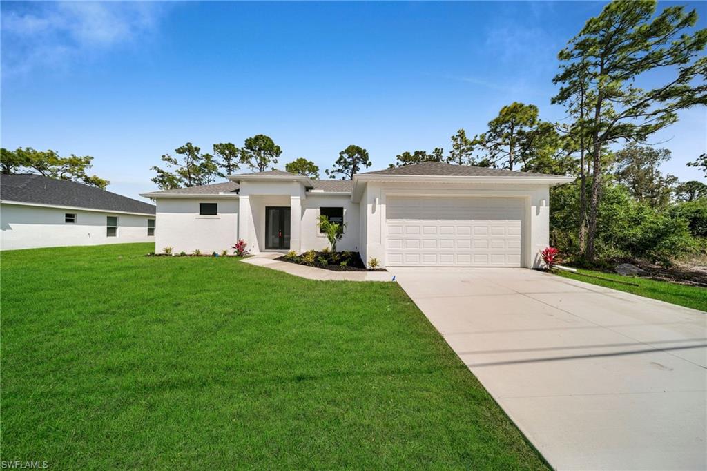 3804 40th Street Southwest Lehigh Acres, FL 33976 - Photo 1 of 24 a front view of a house with a garden and yard