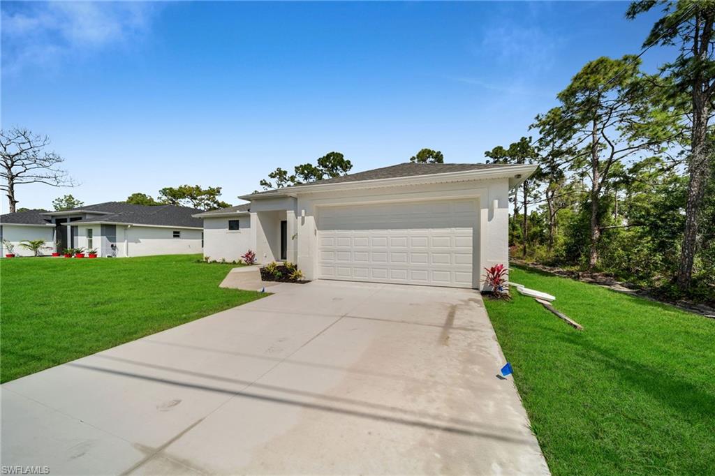 3804 40th Street Southwest Lehigh Acres, FL 33976 - Photo 2 of 24 a view of a white house next to a yard with big trees