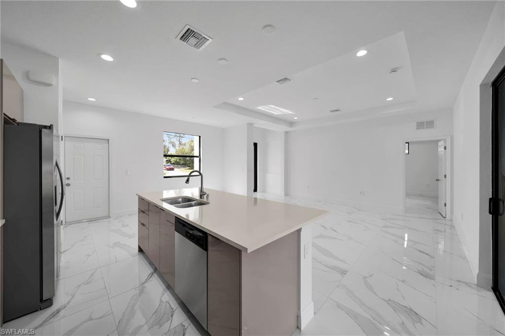 3804 40th Street Southwest Lehigh Acres, FL 33976 - Photo 5 of 24 a kitchen with stainless steel appliances granite countertop a sink and a refrigerator