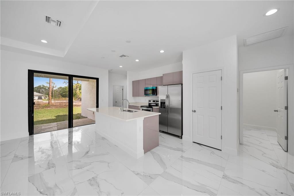 3804 40th Street Southwest Lehigh Acres, FL 33976 - Photo 7 of 24 a view of a kitchen with kitchen island a sink a counter top space and stainless steel appliances