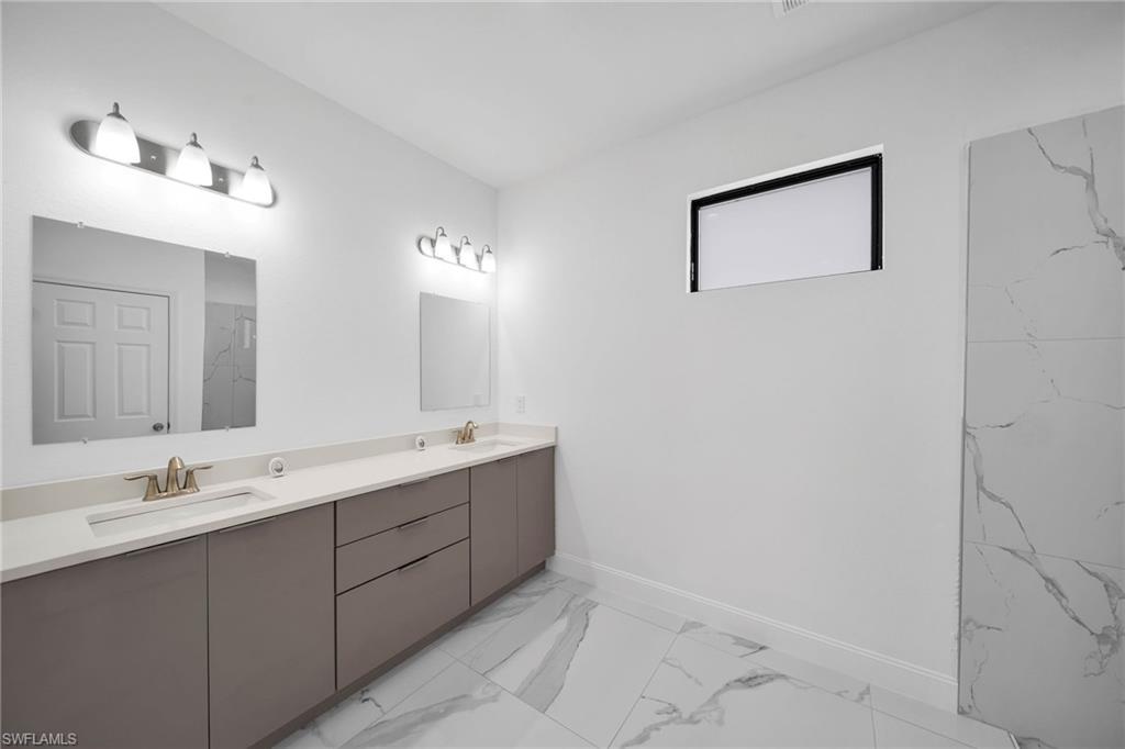 3804 40th Street Southwest Lehigh Acres, FL 33976 - Photo 10 of 24 a bathroom with a double vanity sink and a mirror