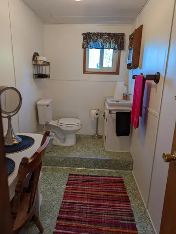 a bathroom with a toilet and a mirror