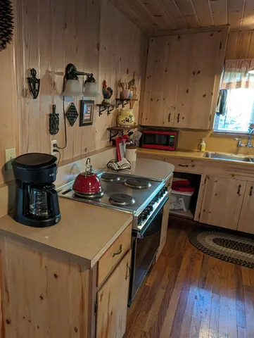 a kitchen with a stove and a wooden floor