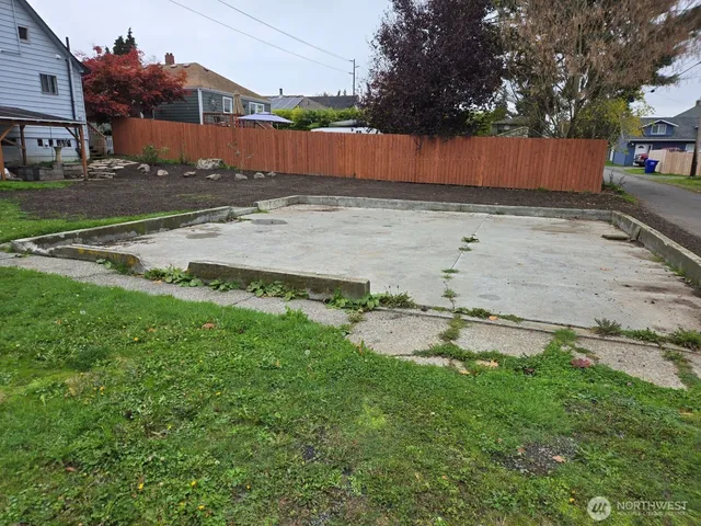 a view of a backyard with wooden fence
