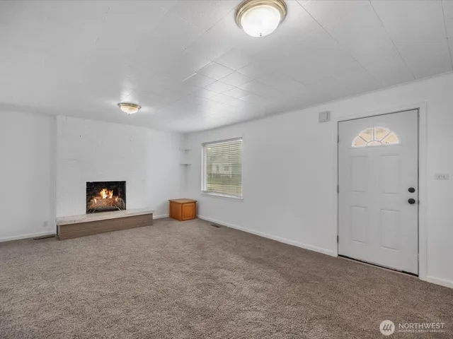 an empty room with a window and fireplace