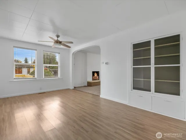 a view of an empty room with a window and wooden floor