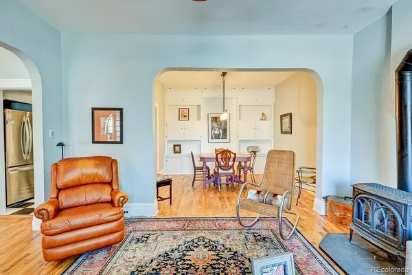 a view of a dining room and livingroom with furniture wooden floor a chandelier