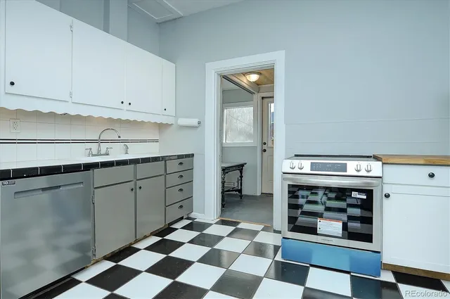 a kitchen with a checkered floor and white cabinets
