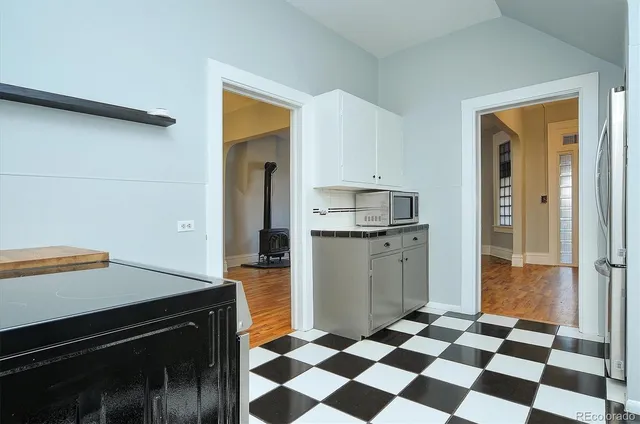 a kitchen with a checkered floor and white cabinets