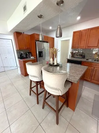 a kitchen with stainless steel appliances kitchen island granite countertop a sink and cabinets