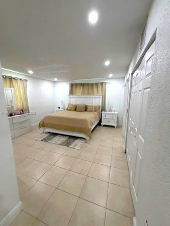 a bedroom with a bed chair and window