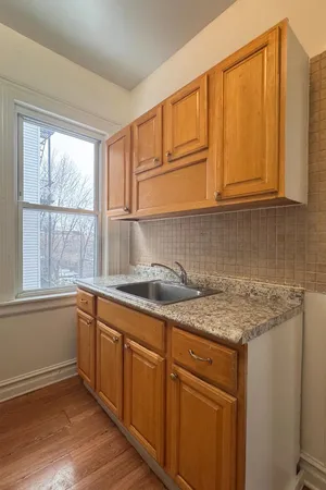 a kitchen with a sink window and cabinets