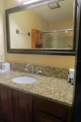 a bathroom with a granite countertop sink and a mirror