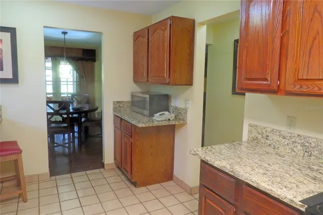 a kitchen with granite countertop a sink a stove and cabinets