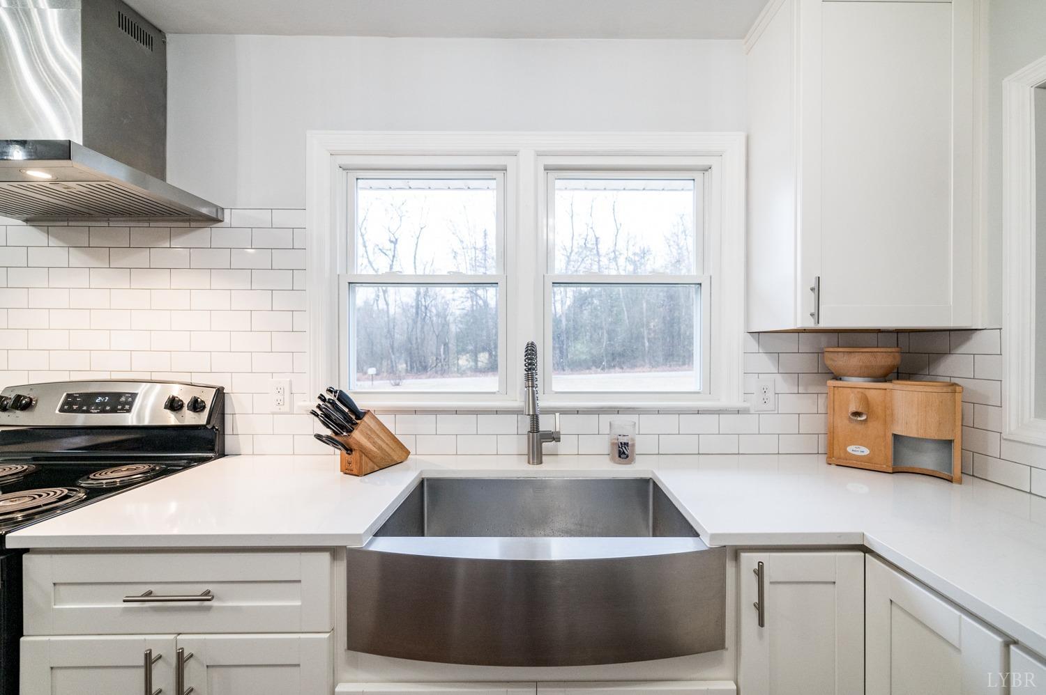 286 Flat Woods Road Amherst, VA 24521 - Photo 11 of 58 a kitchen with a sink a stove and white cabinets