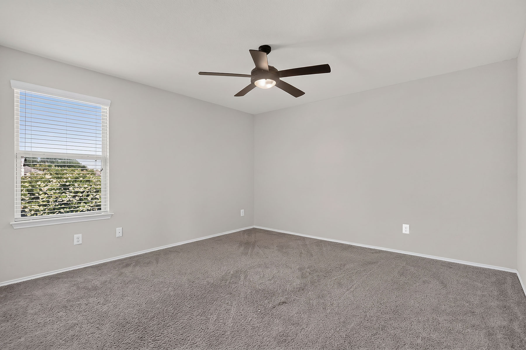 4601 Chestnut Meadows Bend Georgetown, TX 78626 - Photo 21 of 35 An airy bedroom with a ceiling fan and a window overlooking lush greenery.