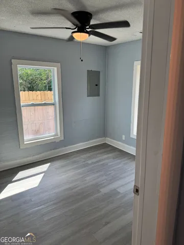 an empty room with wooden floor and windows