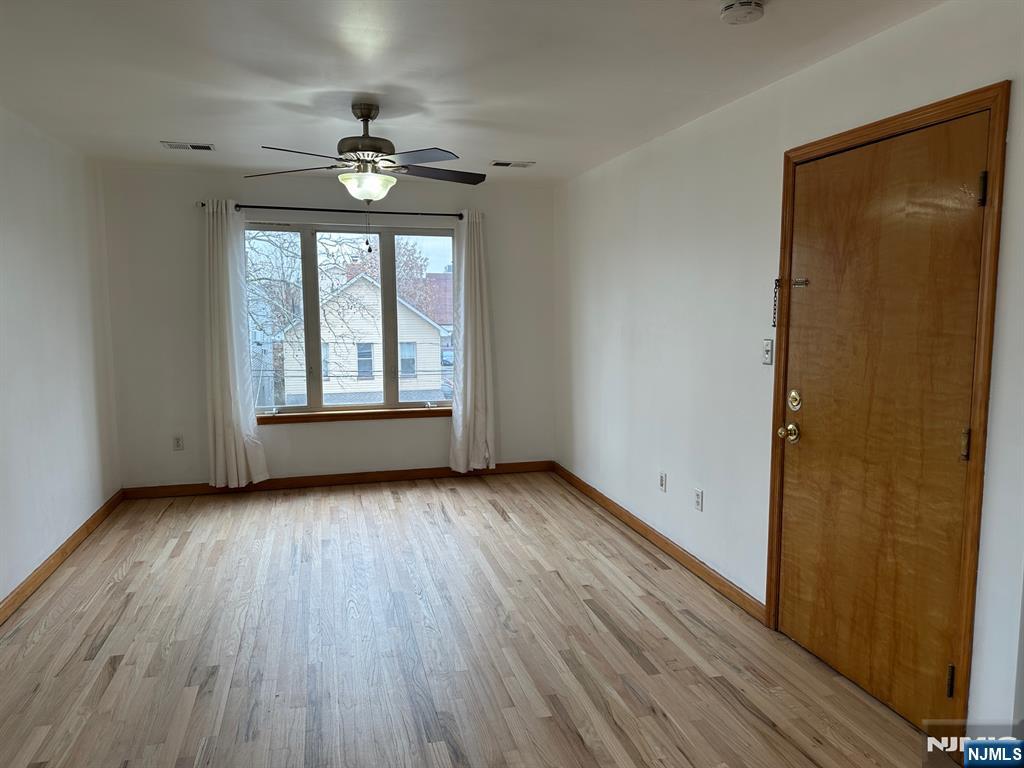 408 Jersey Street Harrison, NJ 07029 - Photo 2 of 10 wooden floor in an empty room with a window