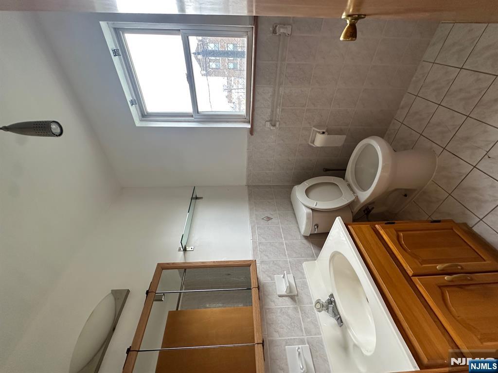 408 Jersey Street Harrison, NJ 07029 - Photo 5 of 10 a bathroom with a toilet sink and mirror