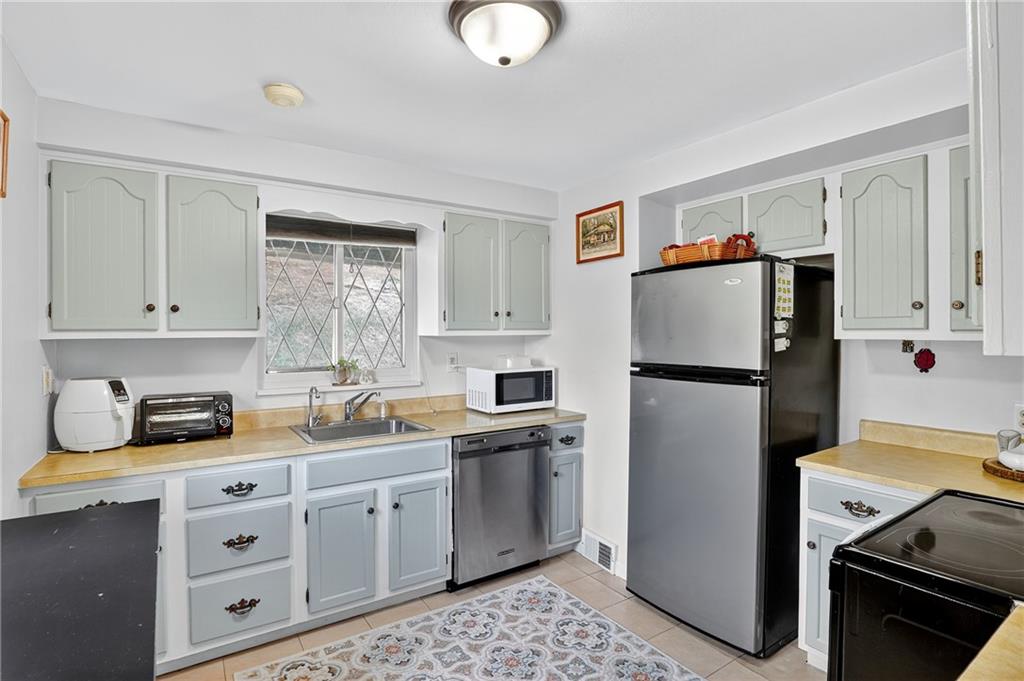 5765 Library Road Bethel Park, PA 15102 - Photo 9 of 34 a kitchen with stainless steel appliances a refrigerator sink and cabinets