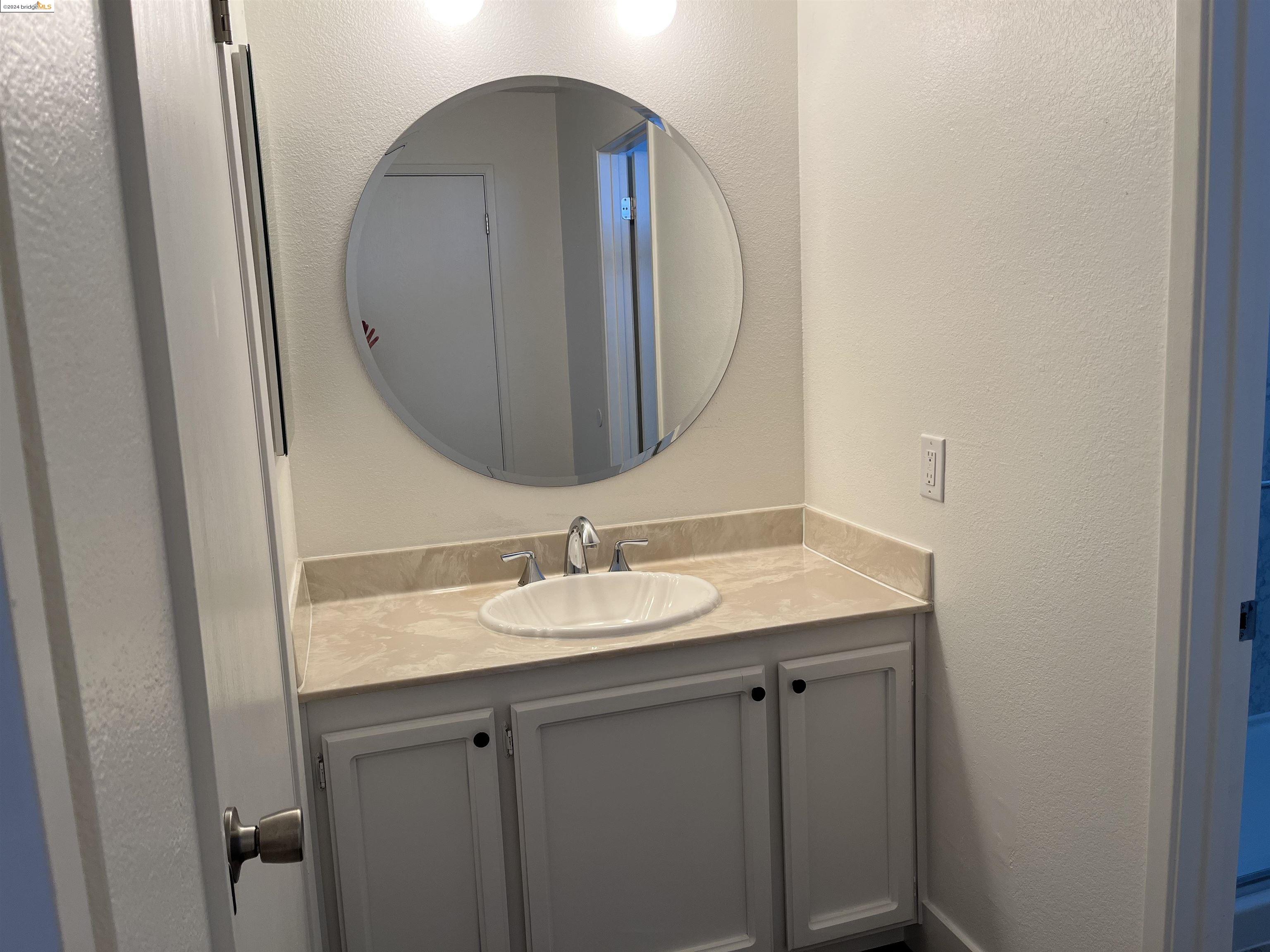 5651 Schooner Loop Discovery Bay, CA 94505 - Photo 13 of 16 a bathroom with a granite countertop sink and a mirror