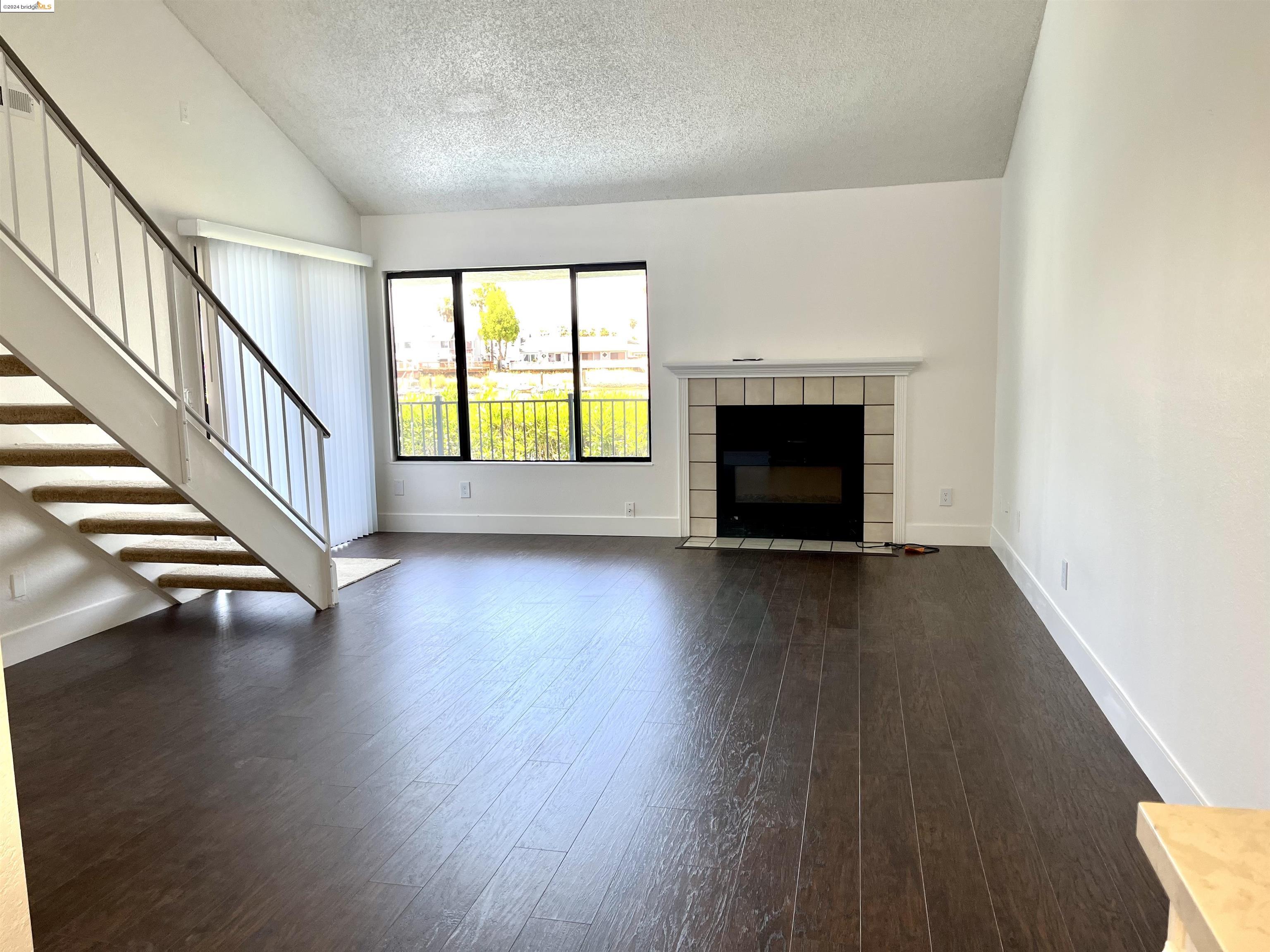 5651 Schooner Loop Discovery Bay, CA 94505 - Photo 5 of 16 an empty room with wooden floor fireplace and windows