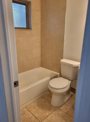 a white toilet sitting next to a bath tub