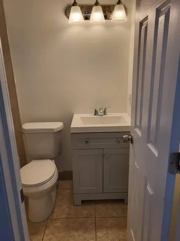 a bathroom with a toilet a sink and mirror