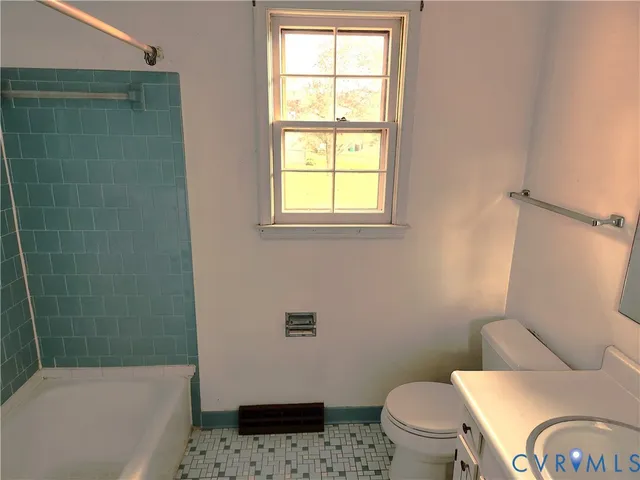 a white toilet sitting next to a bath tub