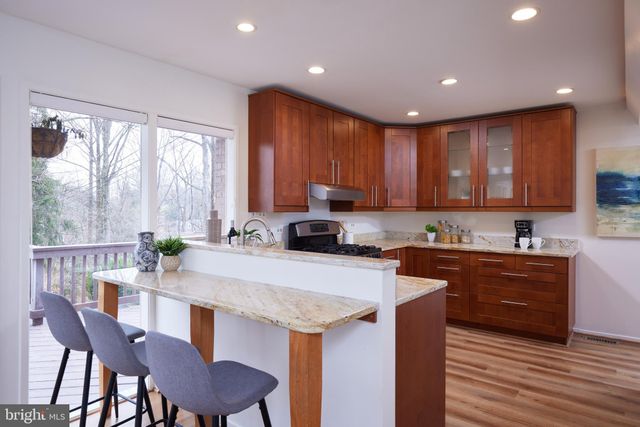 a kitchen with granite countertop wooden cabinets and stainless steel appliances