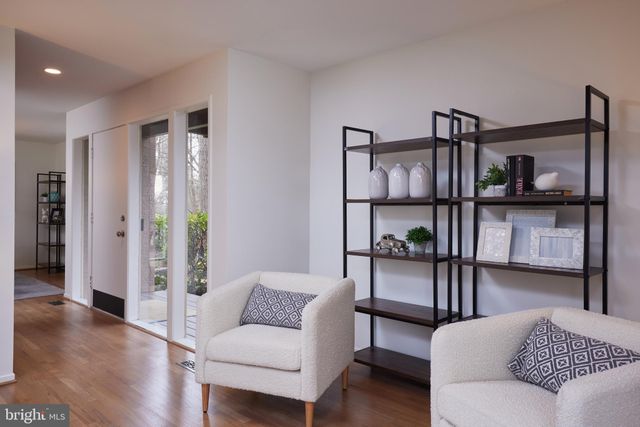 a living room with furniture a fireplace and large windows