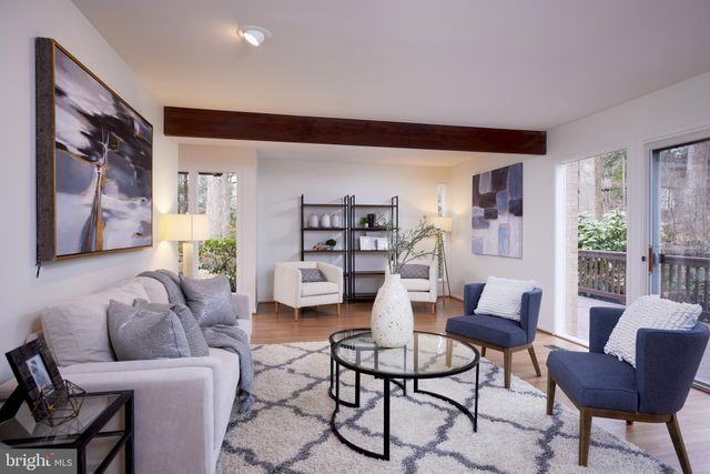 a living room with furniture a fireplace and a floor to ceiling window