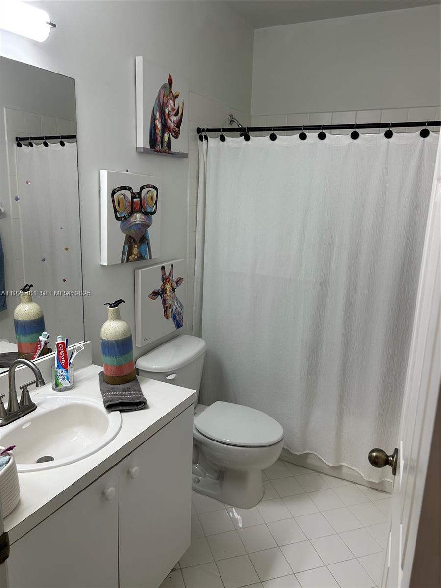 4110 Northeast 24th Street Homestead, FL 33033 - Photo 8 of 16 a bathroom with a sink a toilet and shower curtain