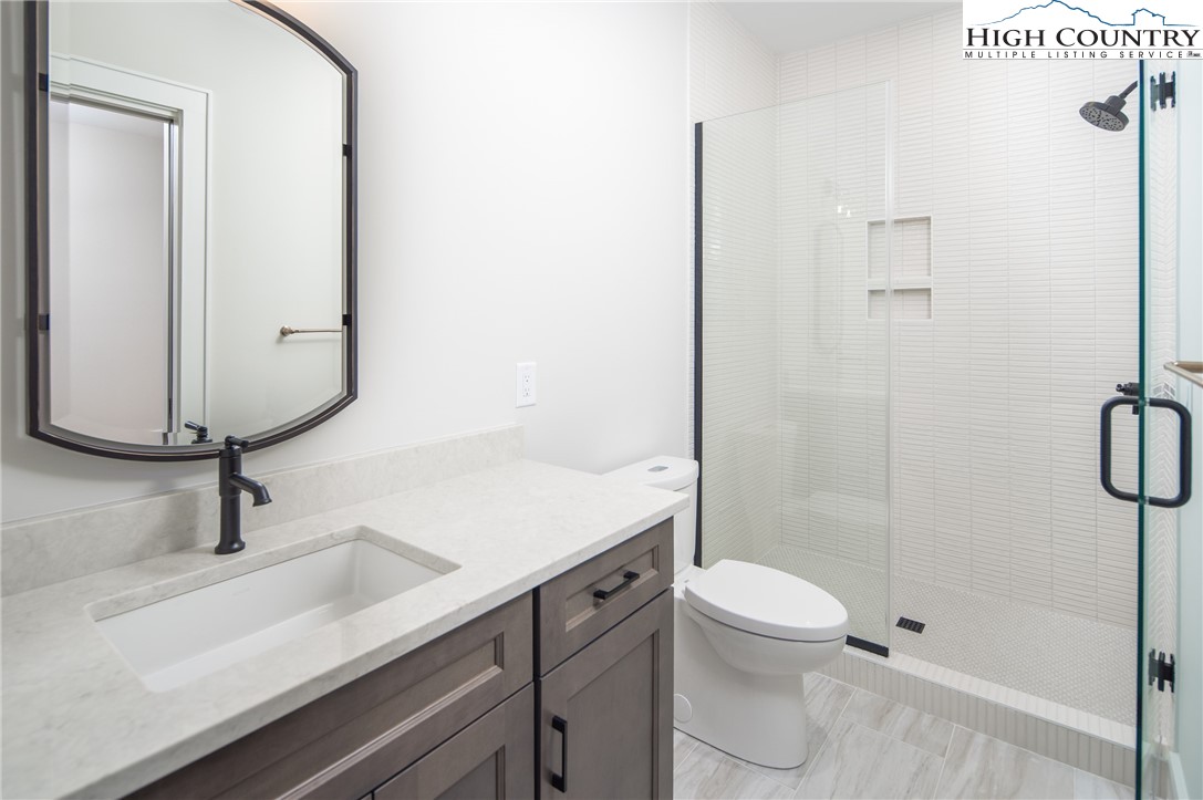 353 Calico Court Boone, NC 28607 - Photo 23 of 50 a bathroom with a sink a toilet and shower