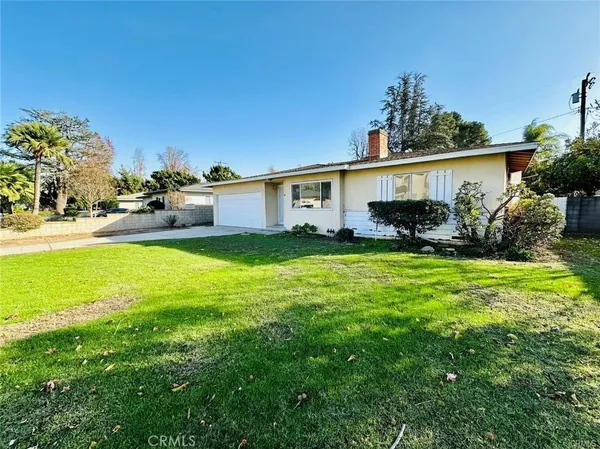 a view of a house with backyard and sitting area