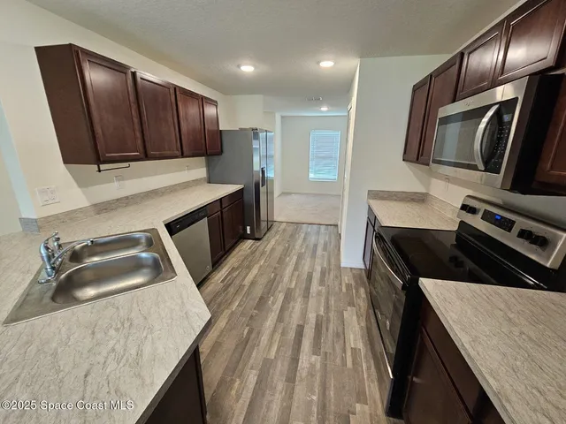 a kitchen with wooden cabinets a sink and a stove