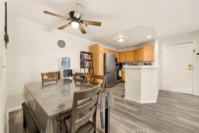 a kitchen with stainless steel appliances granite countertop a table chairs and a refrigerator