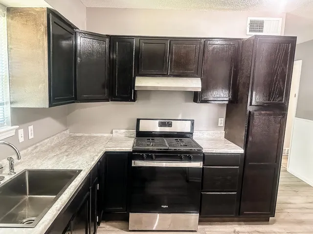 a kitchen with a refrigerator sink and cabinets