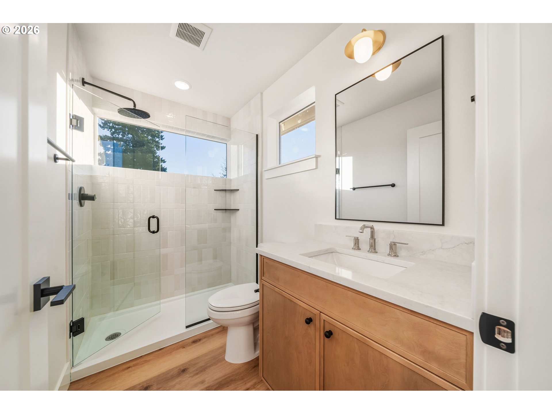 7332 Southeast Bybee Boulevard, Unit 2 Portland, OR 97206 - Photo 16 of 19 a bathroom with a granite countertop sink a toilet a mirror and shower