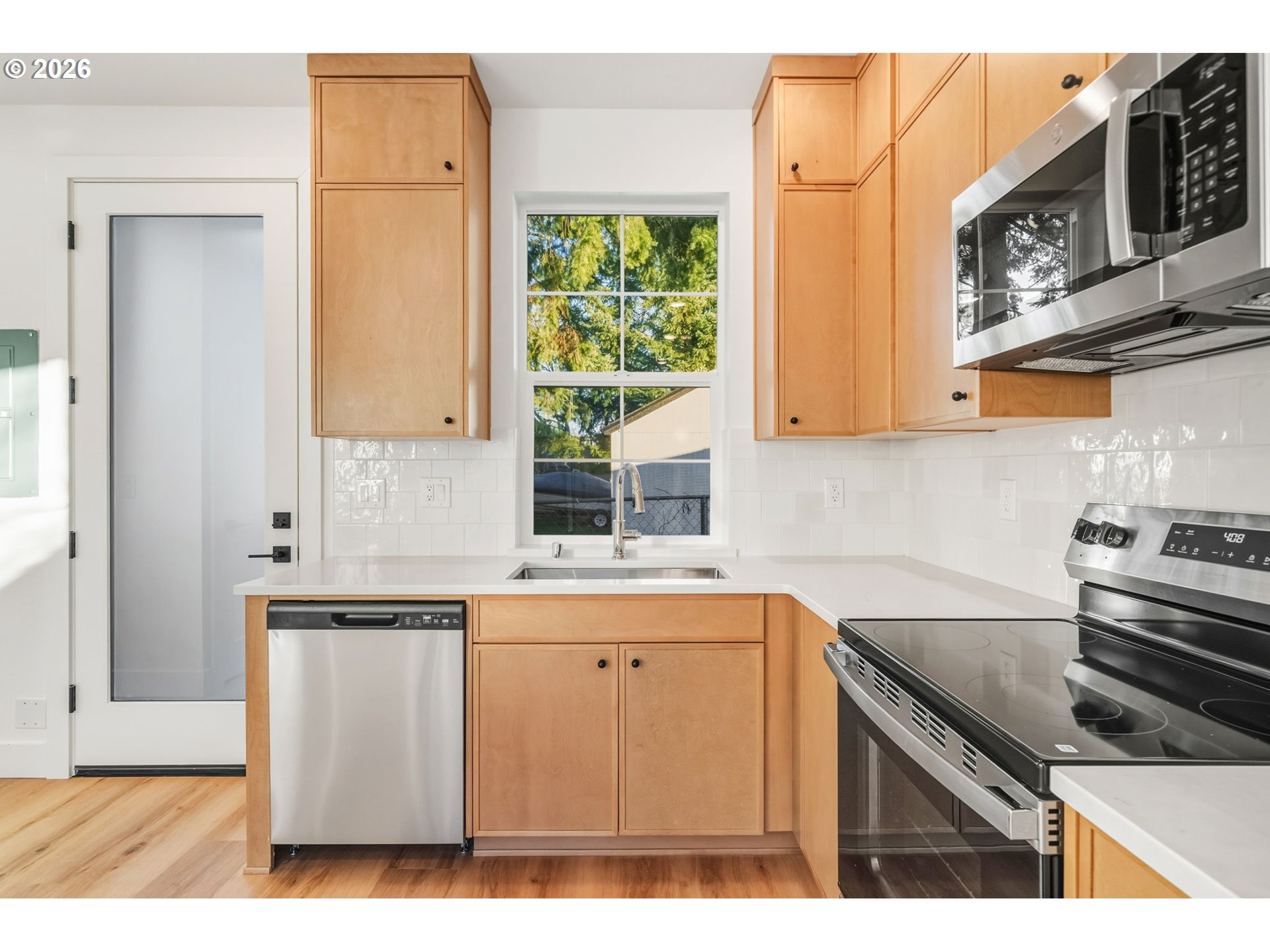 7332 Southeast Bybee Boulevard, Unit 2 Portland, OR 97206 - Photo 5 of 19 a kitchen with stainless steel appliances granite countertop a stove a sink and a microwave