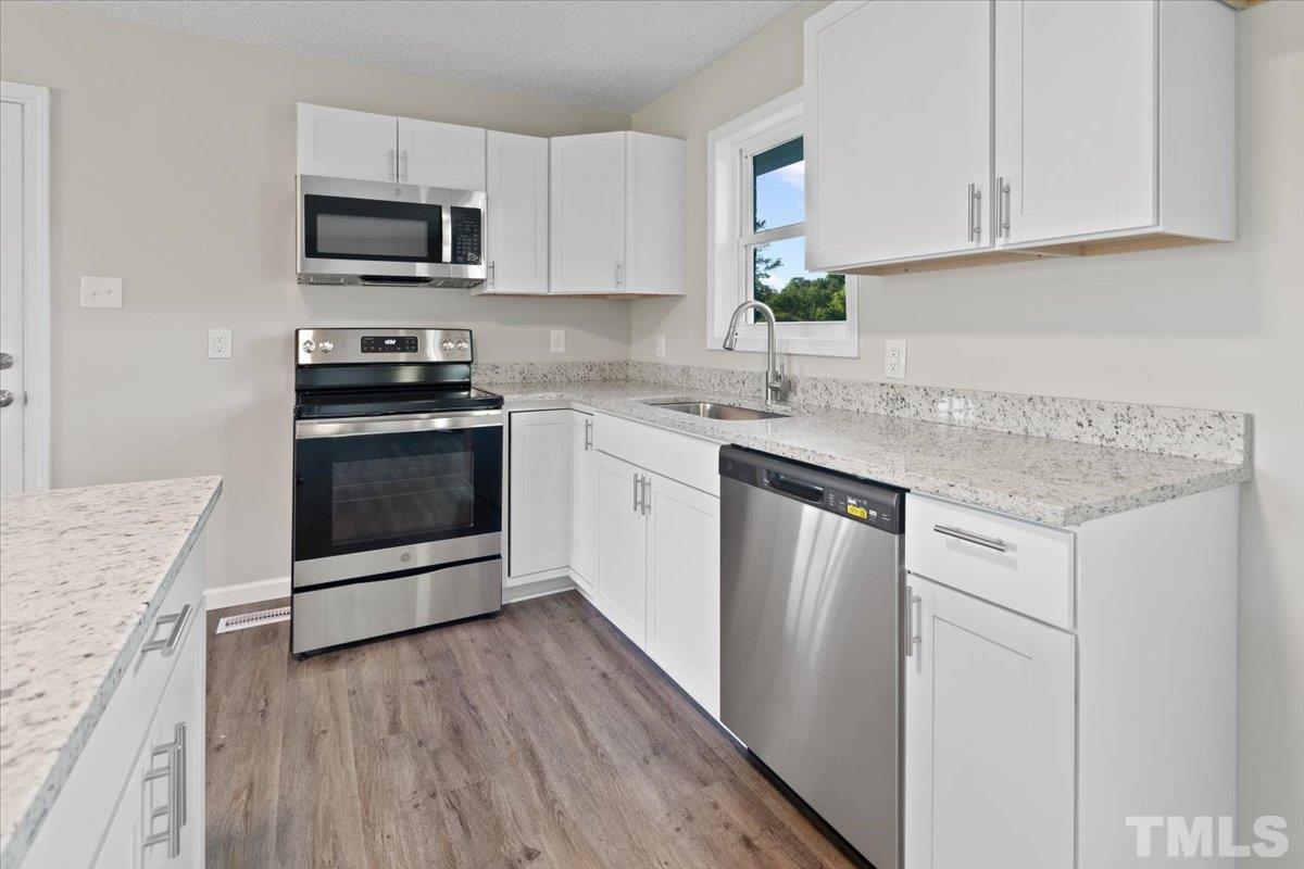 633 Outlaw Road Dudley, NC 28333 - Photo 16 of 28 a kitchen with stainless steel appliances granite countertop a stove a sink and a microwave