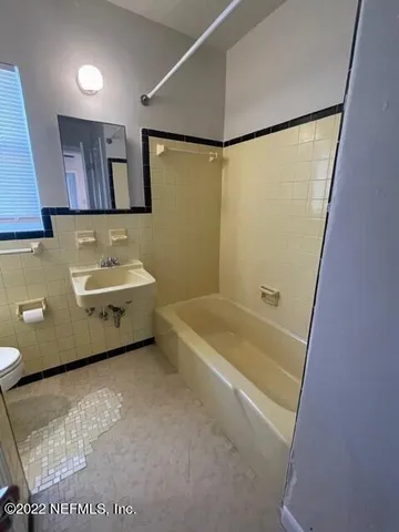 a bathroom with a sink a bathtub a mirror and a shower