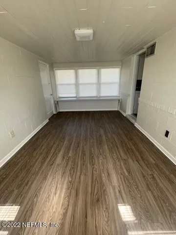 a view of a room with wooden floor and window