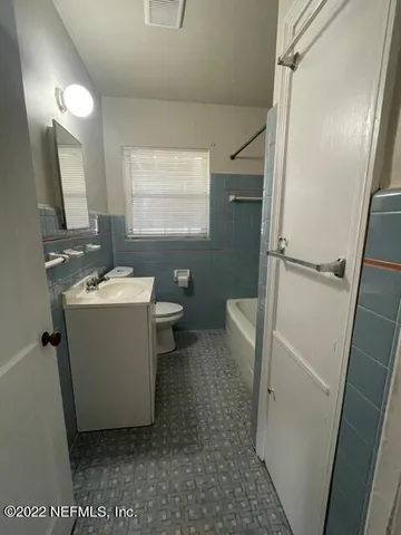 a bathroom with a sink a toilet a mirror and vanity