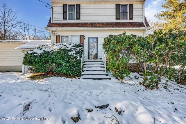an empty room with windows and fireplace