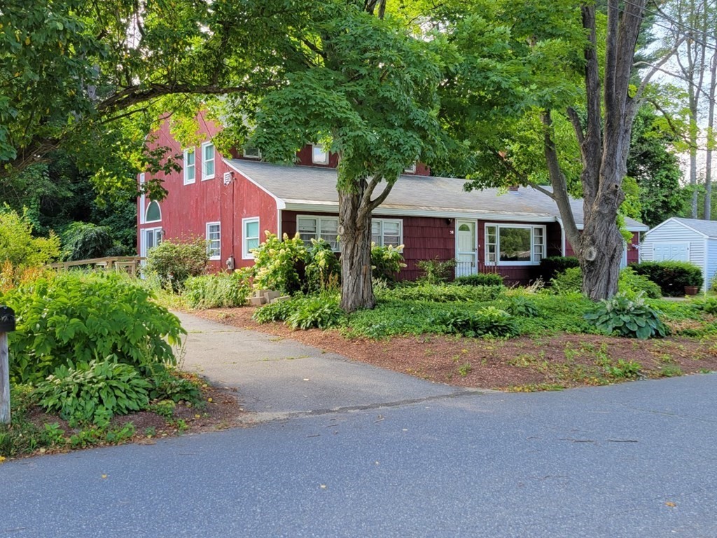 38 Bigelow Road Lancaster, MA 01523 - Photo 1 of 26 a front view of a house with a garden and trees