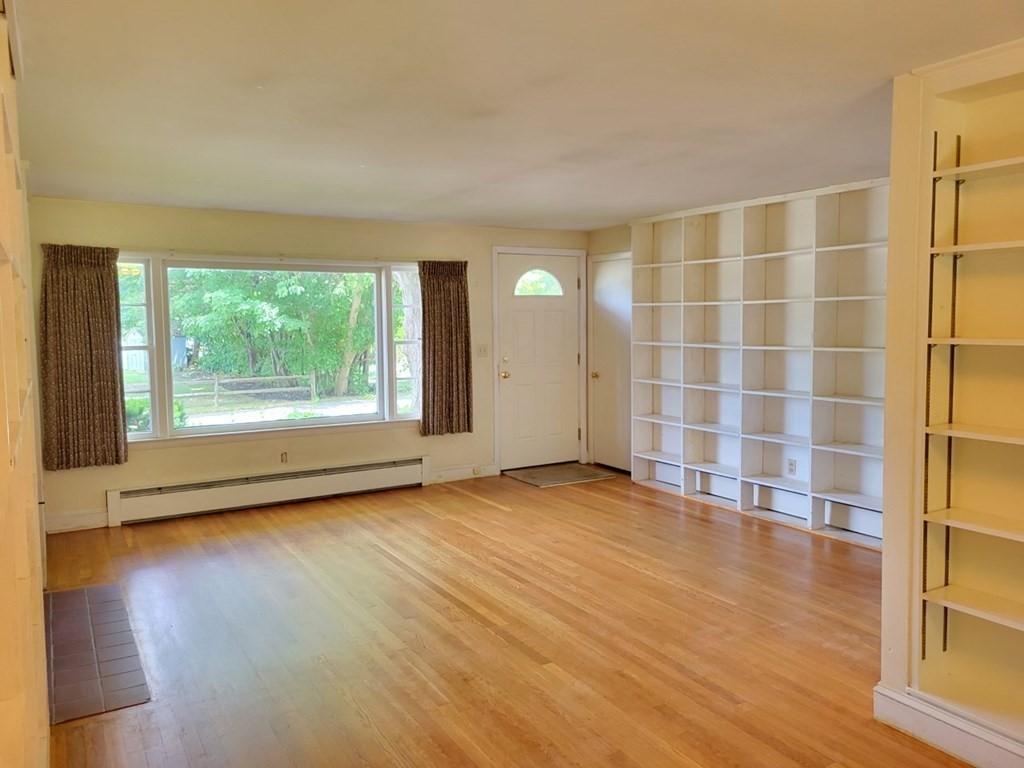 38 Bigelow Road Lancaster, MA 01523 - Photo 9 of 26 a view of an empty room with wooden floor and a window